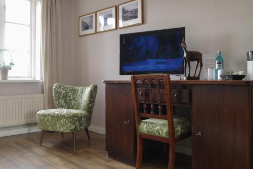 a room with a desk with a tv and a chair at Hotel Restaurant Anno 1617 in Glückstadt