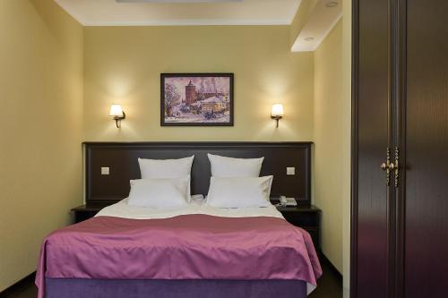コロムナにあるHermitage hotelのベッドルーム1室(紫のシーツと白い枕のベッド1台付)