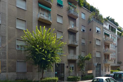 un immeuble d'appartements avec un arbre en face de celui-ci dans l'établissement B&B Via Fontana Milano, à Milan