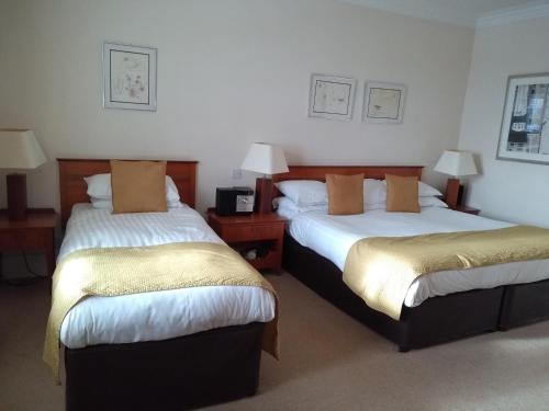 a hotel room with two beds and two lamps at Pitbauchlie House Hotel - Sure Hotel Collection by Best Western in Dunfermline