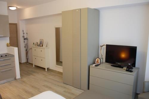 a living room with a tv on a dresser at Luxury Studio 42 De Silva in Mamaia
