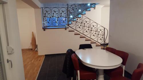 a dining room with a table and a staircase at Villa Buna in Buna