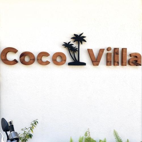 a sign for a coco cola sign on a wall at Coco Villa in Thoddoo