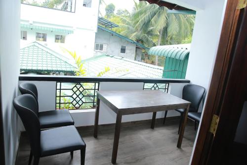 a table and chairs in a room with a window at Ama Residence in Matale