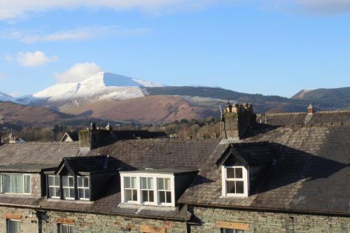 a group of roofs with a snow covered mountain in the background at Dunsford Guest House in Keswick