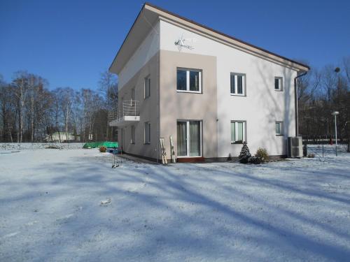a large white house with a lot of snow at Apartmán u Toma in Frýdlant nad Ostravicí
