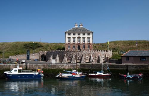 a group of boats in the water in front of a building at Albero Apartment in Eyemouth