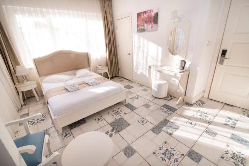 a bedroom with a bed and a tiled floor at Buyukada Cankaya Hotel in Buyukada