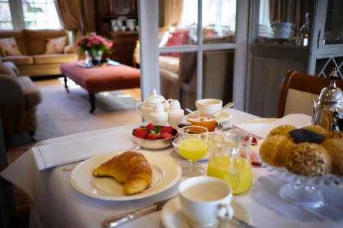 a table with a breakfast of croissants and fruit on it at Romantik Manoir Carpe Diem in De Haan