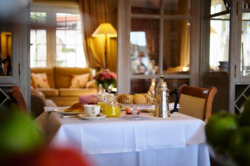a table with a plate of food on it at Romantik Manoir Carpe Diem in De Haan