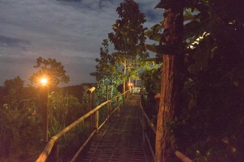 a bridge over a forest at night with lights at Khunyuam Resort in Ban Khun Yuam