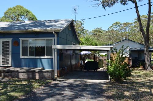 a blue house with a gate in front of it at Casa Husky in Huskisson