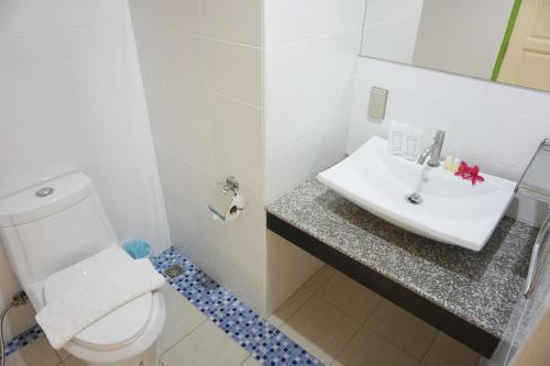 a bathroom with a white toilet and a sink at Amphawaree in Samut Songkhram