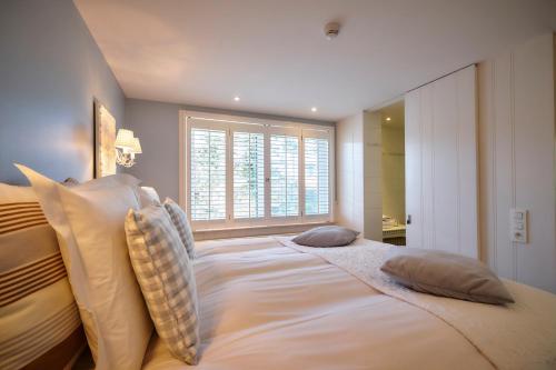a bedroom with a large bed with pillows and a window at Romantik Manoir Carpe Diem in De Haan