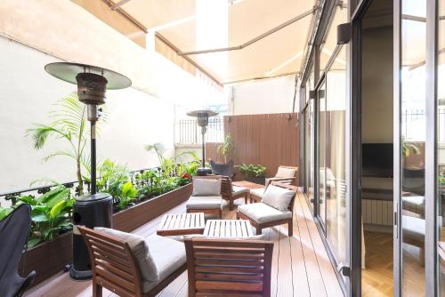 a balcony with chairs and tables and plants at BUHO Boutique Rooms in Barcelona