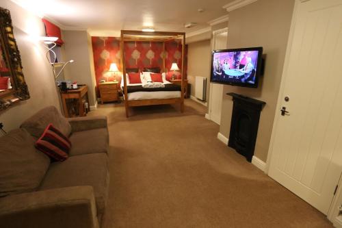 a living room with a couch and a flat screen tv at Woodlands in Windermere