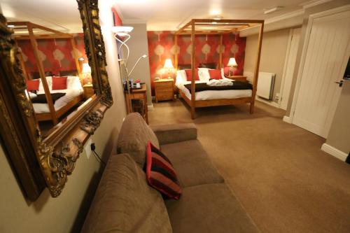 a living room with a couch and a mirror at Woodlands in Windermere