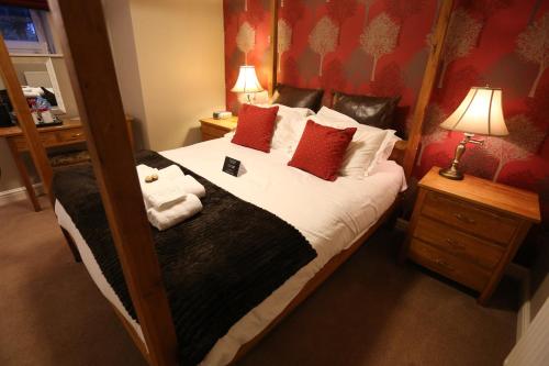a bedroom with a large bed with red pillows at Woodlands in Windermere