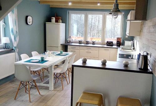 a kitchen with a table and a white table and chairs at Bobrowa Przystań in Czechyń