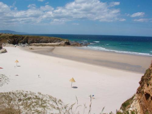 a white beach with the ocean in the background at Casa do Merlo in Barreiros