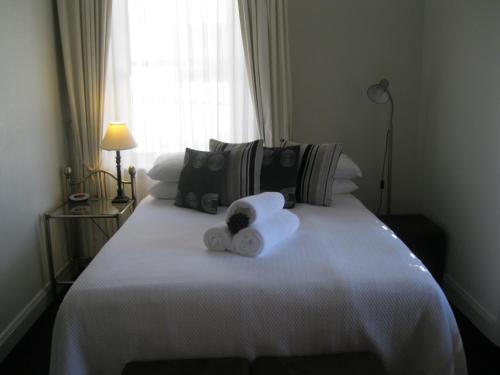 a white bed with white sheets and pillows at Heritage Guesthouse in South West Rocks
