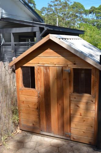 a wooden garage with a roof on top of it at Casa Husky in Huskisson