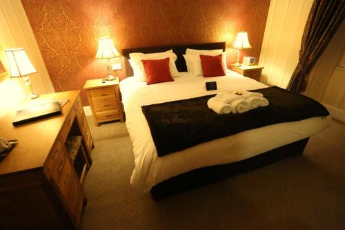 a hotel room with a large bed with two lamps at Woodlands in Windermere