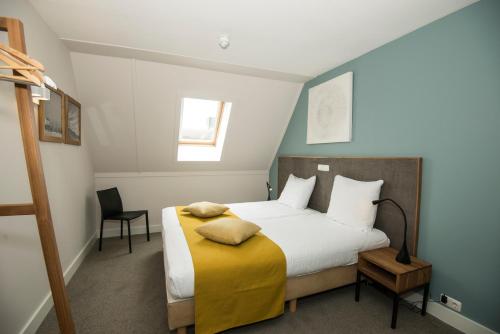 een slaapkamer met een groot bed en een gele deken bij Vlierijck in Oost-Vlieland