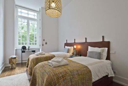 a bedroom with two beds and a chandelier at Libest Av. da República 1 - Saldanha in Lisbon