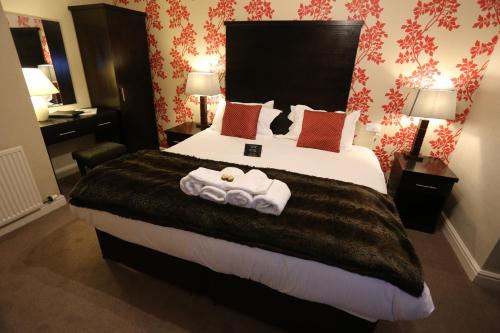 a hotel room with a large bed with towels on it at Woodlands in Windermere