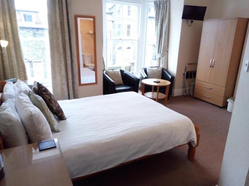 Habitación de hotel con cama y sala de estar. en Dunsford Guest House en Keswick