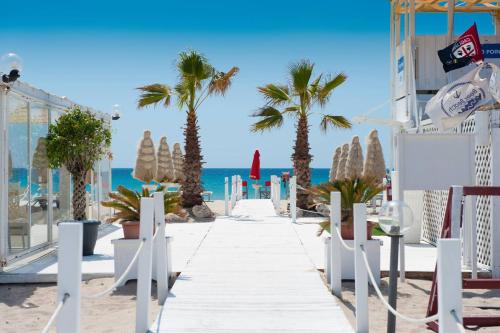 a pathway on the beach with palm trees and the ocean at Fede & Francy in Quartu SantʼElena