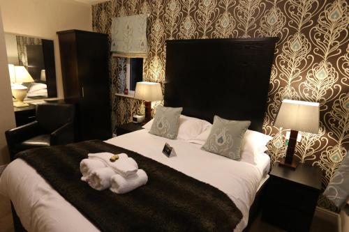 a hotel room with a bed with towels on it at Woodlands in Windermere