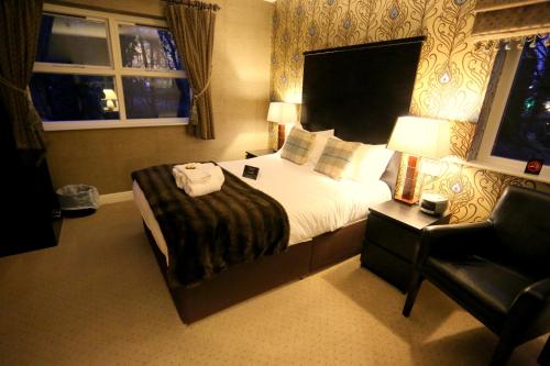 a hotel room with a bed and a chair at Woodlands in Windermere