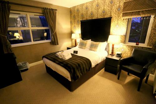 a hotel room with a bed and a chair at Woodlands in Windermere