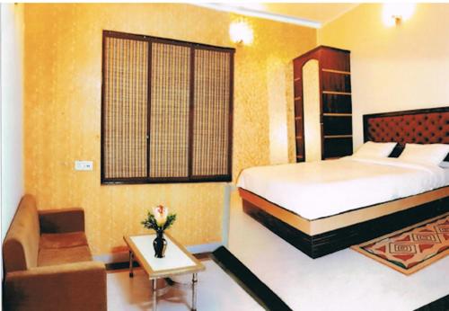 ein Hotelzimmer mit einem Bett und einem Sofa in der Unterkunft Hotel Traditional Inn in Neu-Delhi