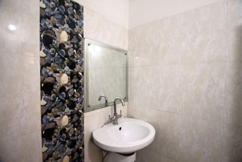 ein Bad mit einem Waschbecken und einem Spiegel in der Unterkunft Hotel Traditional Inn in Neu-Delhi