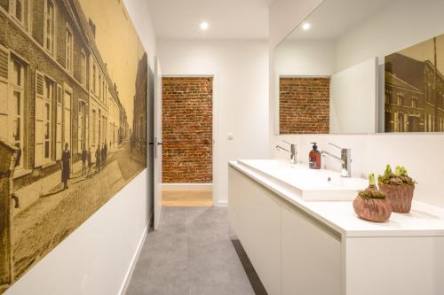 un bagno con due lavandini e un grande dipinto sul muro di Logement Den Beer a Meerhout