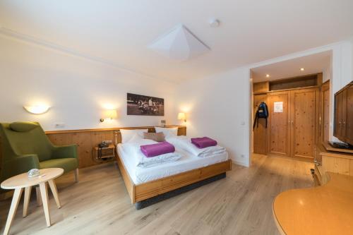 a bedroom with a bed with purple pillows on it at Naturparkhotel Adler in Wolfach
