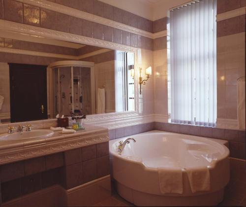 a bathroom with a tub and a sink and a mirror at Baltic Star Villas in Petergof
