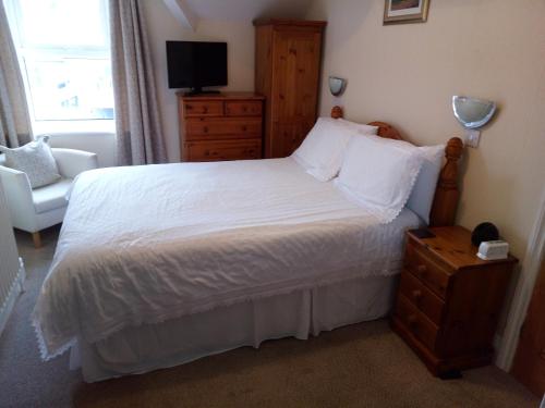 
A bed or beds in a room at Dunsford Guest House
