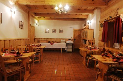 a restaurant with wooden tables and a bed in a room at Penzión Koliba in Dolný Kubín