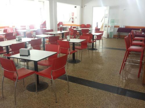 uma sala de jantar com mesas e cadeiras vermelhas em Hotel Palace Piriápolis em Piriápolis