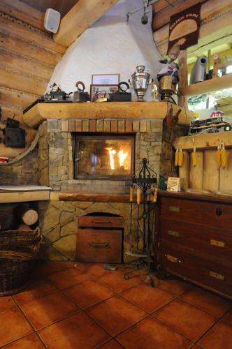 uma sala de estar com lareira de pedra numa casa em Penzión Koliba em Dolný Kubín