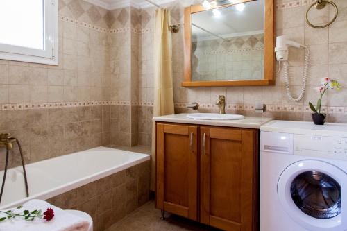 a bathroom with a washing machine and a sink at Azalea in Vasiliki