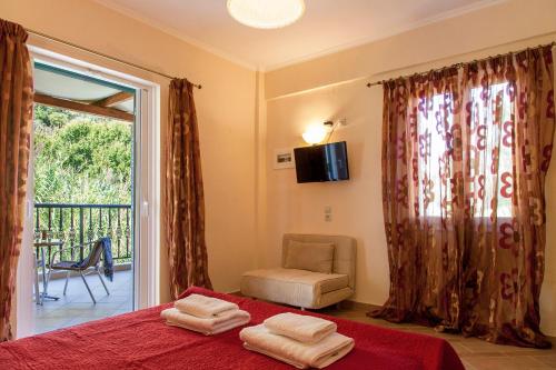 a bedroom with a bed and a window with a chair at Azalea in Vasiliki
