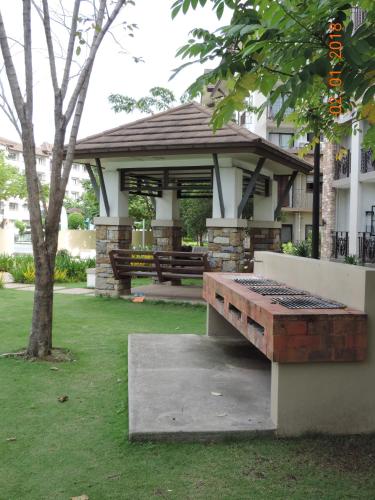 a gazebo with a bench in a yard at Honey's Elysees Condotel - Davao in Davao City