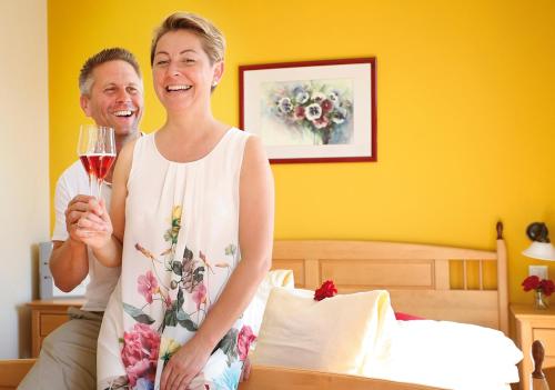 a man and a woman holding a glass of wine at Weingut Winzerhof Gästezimmer Grebenz in Großklein