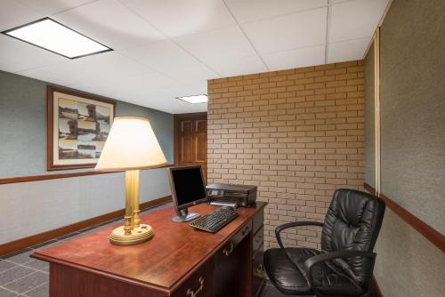 an office with a desk with a computer and a lamp at Ramada Plaza by Wyndham Portland in Portland