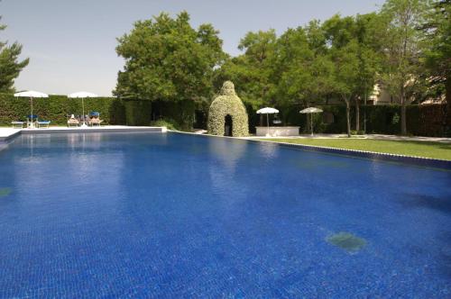 a large blue swimming pool in a yard with umbrellas at Villa Maria Hotel & SPA in Francavilla al Mare